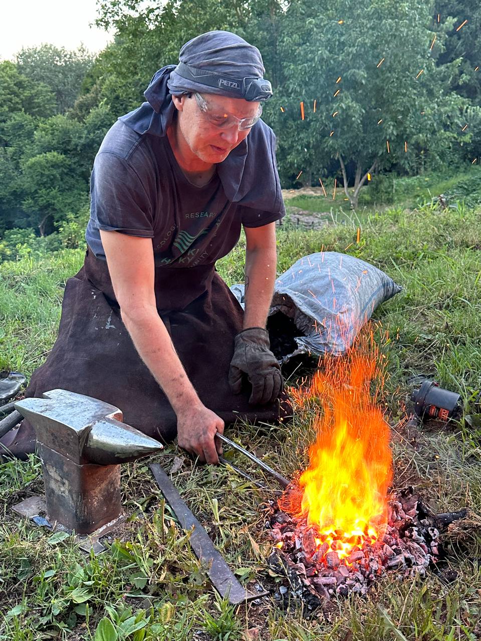 Bogdan Popov working outdoors beside a live forge fire
